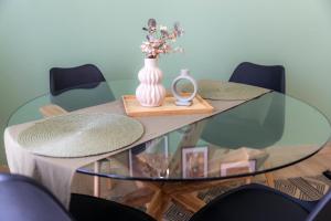 a glass table with a vase and a mirror on it at Korte Apartment 2 in Arta