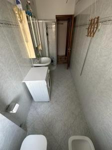 łazienka z 2 toaletami i umywalką w obiekcie Cozy home baranzate w mieście Baranzate