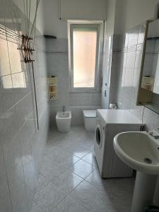 a white bathroom with a sink and a toilet at Cozy home baranzate in Baranzate