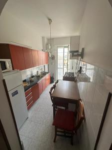 uma cozinha com uma mesa e uma cozinha com um frigorífico em Cozy home baranzate em Baranzate