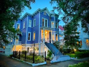 a large blue house with stairs in front of it at Amethyst Garden in Savannah