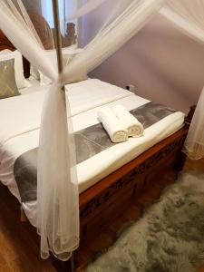 a bed with white sheets and towels on it at Teresita Home in Nairobi