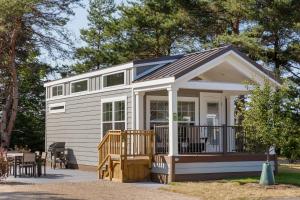 a tiny house with a porch and a deck at Jellystone Park TM Petoskey in Petoskey