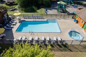 an overhead view of a swimming pool with chairs and a playground at Jellystone Park TM Petoskey in Petoskey