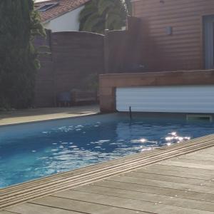 einen Pool mit blauem Wasser vor einem Haus in der Unterkunft Maison avec piscine au calme à 2 pas de Bordeaux in Mérignac