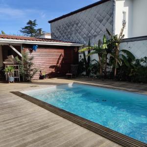 ein Pool vor einem Haus in der Unterkunft Maison avec piscine au calme à 2 pas de Bordeaux in Mérignac
