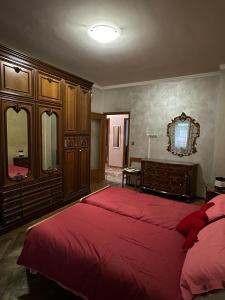 a bedroom with a large bed with red sheets at Da Tiziana in Turin