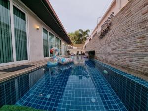 a swimming pool with blue tiles in a building at Peter Pan Poolvilla in Jomtien Beach