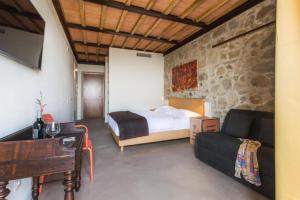 een slaapkamer met een bed en een bank bij VALDONICA Winery I Residence I Restaurant in Sassofortino