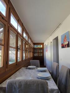 a dining room with a table and chairs and windows at La Casa dei Turchi in Rovereto