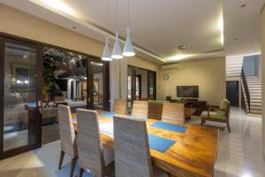 Elegant 6 Bedrooms Luxury Villa Near Pandawa Beach في نوسا دوا: غرفة طعام مع طاولة وكراسي خشبية