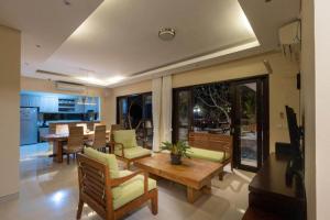 Elegant 6 Bedrooms Luxury Villa Near Pandawa Beach في نوسا دوا: غرفة معيشة مع طاولة وكراسي خشبية