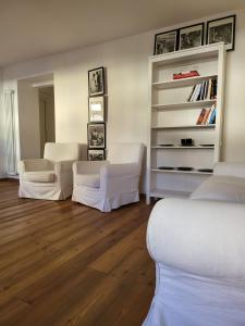 a room with two white couches and a book shelf at La Casa dei Turchi in Rovereto