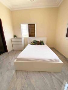 a large white bed in a room with at KMR Apartment - Sira in Sere Kunda
