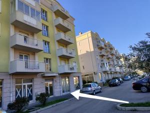 a building with a car parked in a parking lot at Apartman Cherine in Mostar