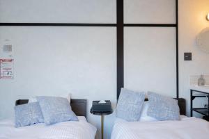 sypialnia z 2 łóżkami i białymi i niebieskimi poduszkami w obiekcie Niseko Powder Chalet w mieście Kutchan