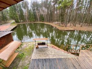 a view of a small pond with a wooden dock at Complex MAYARIV in Mar'yanovka