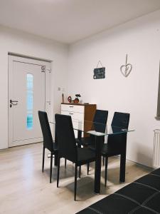 a dining room with a glass table and black chairs at Pinny Apartment in Portorož