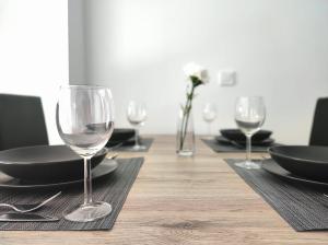 a table with wine glasses and plates on it at Ohana homes 3 in Málaga
