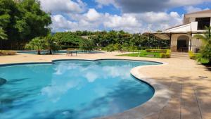 a swimming pool with blue water in a yard at New 3 bedroom Home in Managua in Managua