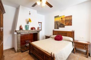 1 dormitorio con 1 cama y chimenea en Casa Generalife, bei Granada, en Dúrcal