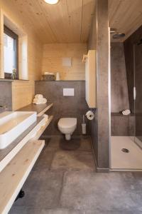 a bathroom with a toilet and a tub and a sink at Streuobst Chalets in Neukirch +21 photos