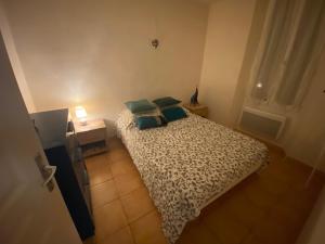 a small bedroom with a bed with green pillows at Coeur de village in Bormes-les-Mimosas