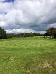 a green field with a red flag in the middle of it at H9 Fairway Holiday Park Sandown in Sandown