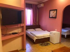 a room with two beds and a television in a room at Hrashq Hotel in Yerevan
