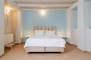 a bedroom with a large white bed with two tables at Casa Romana in Bucharest