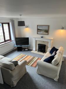 een woonkamer met 2 banken en een open haard bij SeaCross Sheringham Norfolk Coast 3 Bed Detached house in Sheringham