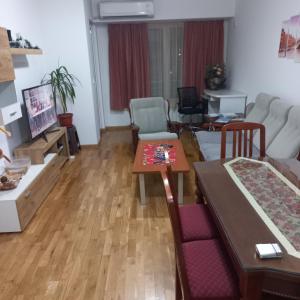 ein Wohnzimmer mit einem Tisch und einem Sofa in der Unterkunft Cozy Skopje Retreat in Skopje