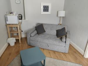 a living room with a gray couch with two pillows at Kings Arms Hotel in Kirkby Lonsdale