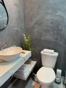 Łazienka z białą toaletą i umywalką w obiekcie Conves suites w mieście Penha