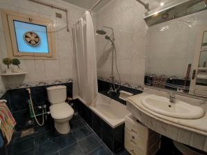 a bathroom with a toilet and a tub and a sink at شقه مفروشه مميزه جدا لعائله بالدقي in Cairo