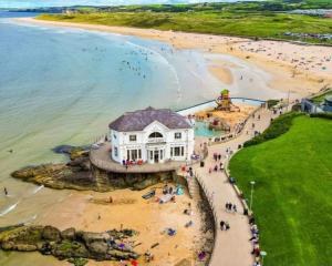 a building on a beach with a crowd of people at Avarest House BB Adults Only in Portrush