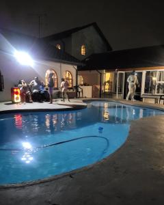 Johannesburg的住宿－Sky view Guest House，一群人晚上坐在游泳池周围