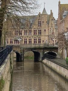 a bridge over a river in front of a building at Vakantiehuis En Passant in Diksmuide