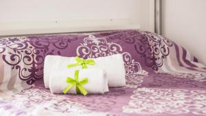 uma cama roxa com duas toalhas brancas com arcos verdes em Tenute Donna Franca em Elice