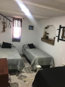 a room with two beds and a window in it at Habitación doble in Ciudad Lujan de Cuyo