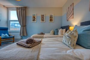 a living room with two beds and a couch at Modern 2-Bed Stylish Contractor House, Prime Portsmouth Location & Parking - By Blue Puffin Stays in Portsmouth