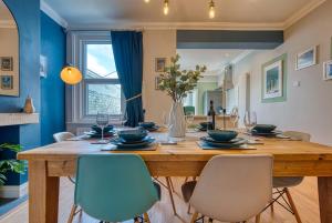 a dining room with a large wooden table and chairs at Modern 2-Bed Stylish Contractor House, Prime Portsmouth Location & Parking - By Blue Puffin Stays in Portsmouth