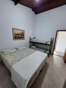 1 dormitorio con 1 cama y una foto en la pared en Casa de Hóspede Canto do Canto, en Itapetininga