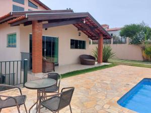 un patio con mesa y sillas junto a una piscina en Casa de Hóspede Canto do Canto, en Itapetininga