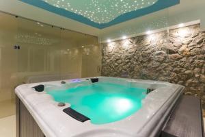 a large bath tub with blue water in a bathroom at Villa Aqua in Zaboric