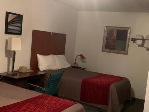 Habitación de hotel con 2 camas, escritorio y mesa en Franklin Motel, en Assiniboia