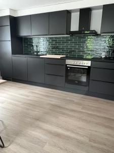 a kitchen with black appliances and a wooden floor at Panorama Appartements in Egg