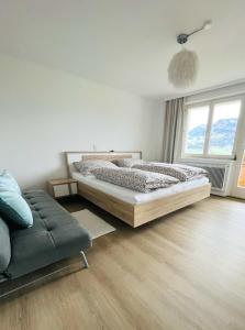 a bedroom with a large bed and a couch at Panorama Appartements in Egg