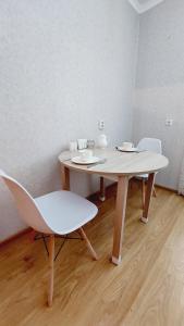 stół i krzesła w pokoju z drewnianą podłogą w obiekcie Аэропорт Астана w mieście Prigorodnyy