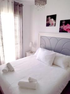 塞維利亞的住宿－Casa Blanca，卧室配有白色的床和2条毛巾